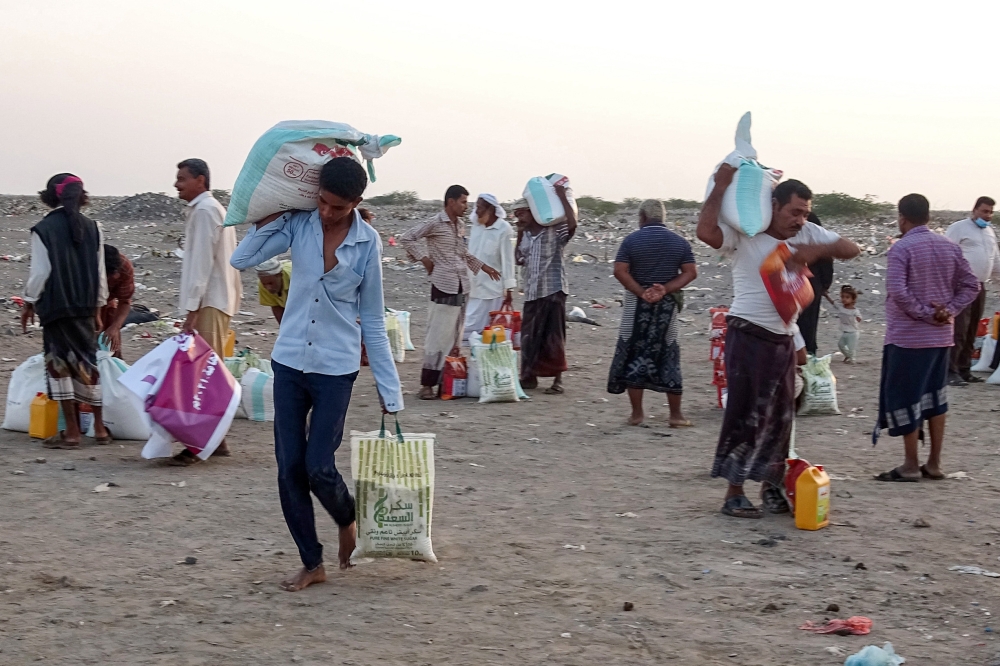 نازحون بسبب النزاع يتلقون مساعدات غذائية في مديرية الخوخة بمحافظة الحديدة غربي اليمن التي دمرتها الحرب أ.ف.ب