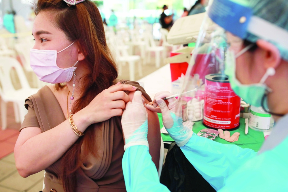 امرأة تتلقى لقاحًا ضد مرض كورونا في بانكوك امس. رويترز 