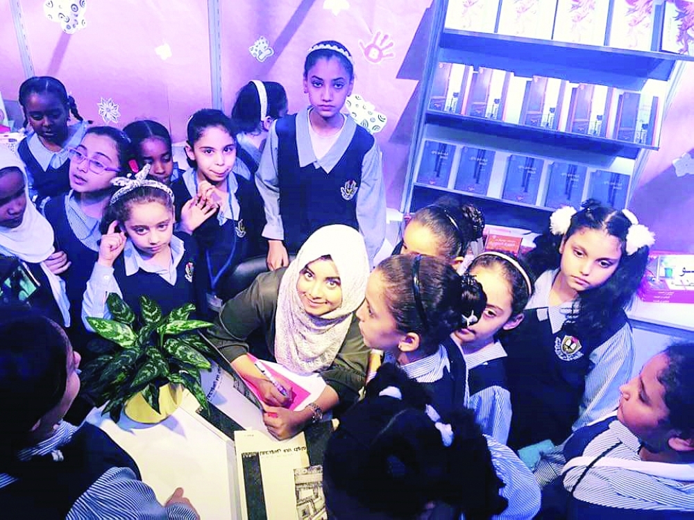 ■ عبير وحولها القراء الصغار أثناء توقيع قصة «الفتى المحبوس في طوله»