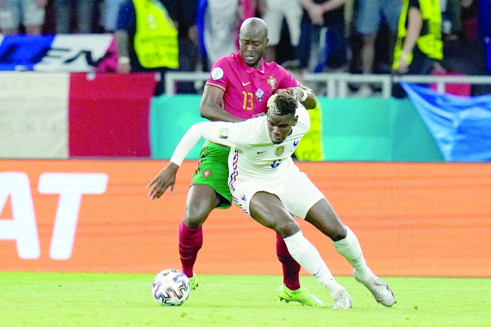 دانيلو بيريرا يحاول ايقاف تقدم بول بوجبا خلال لقاء البرتغال وفرنسا   ( أ ف ب ) 