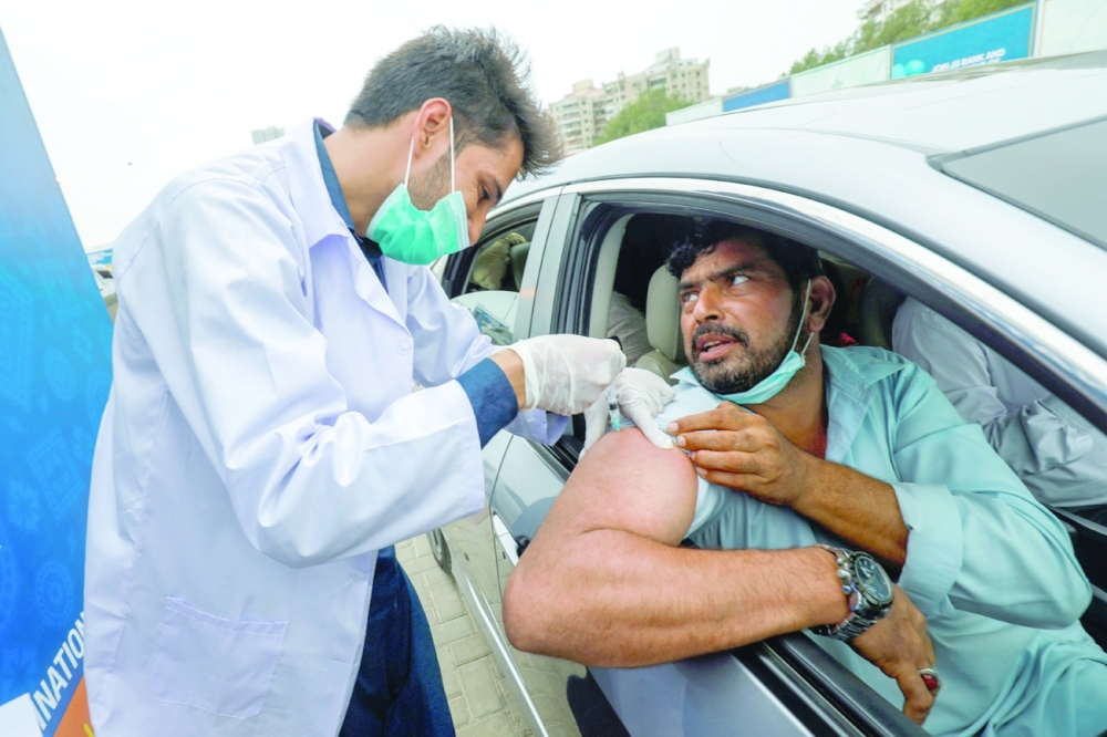 مواطن باكستاني يتلقى اللقاح ضد مرض فيروس كورونا في منشأة تطعيم في كراتشي.  رويترز 