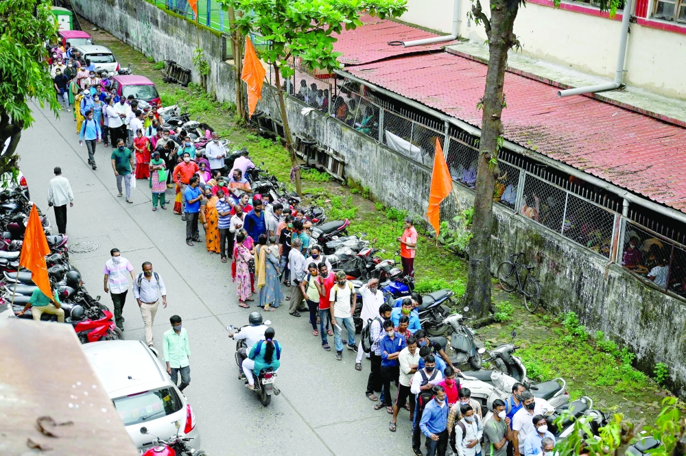 اناس يصطفون في طوابير طويلة، لتلقي اللقاح، في مومباي، امس.           ا ف ب