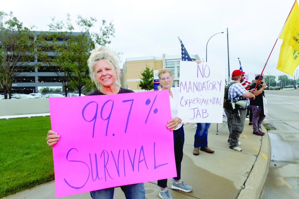 سو روان ، من  أوهايو ، تحمل لافتة للاحتجاج على تفويضات لقاح فيروس كورونا (COVID-19) في مستشفى الصحي في أكرون ، أوهايو الولايات المتحدة .رويترز.