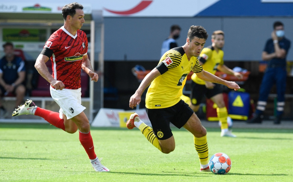 صراع على الكرة بين لاعبا دورتموند وفرايبورغ نيكولاس هوفلر وجيوفاني رينا