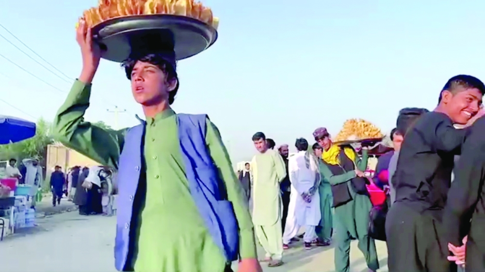  بائعون أفغان يحملون صواني طعام خارج مطار كابول