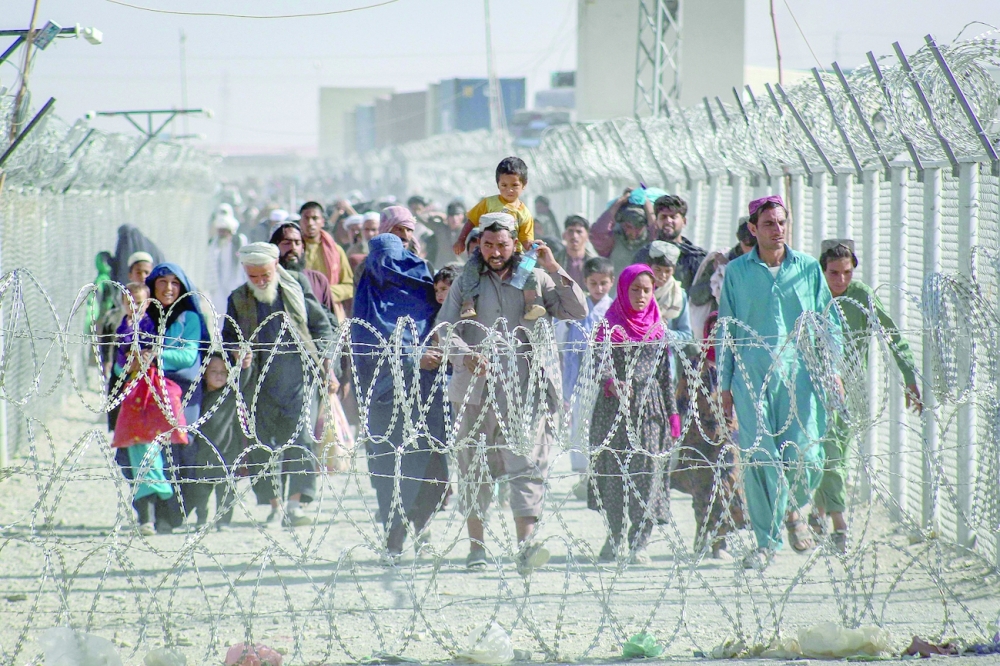 الأفغان يسيرون على طول الأسوار عند وصولهم إلى باكستان عبر نقطة العبور الحدودية الباكستانية الأفغانية في شامان.أ.ف.ب