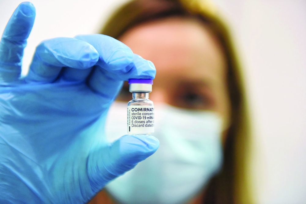 عاملة في المجال الطبي تحمل قنينة من الجرعة الثالثة من لقاح فايزر  في مركز التطعيم بلغراد فير في بلغراد ، صربيا  امس . رويترز   