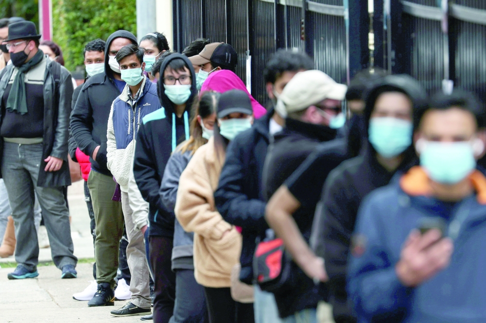  أشخاص ينتظرون في طابور خارج عيادة للتطعيم في سيدني، أستراليا.     رويترز