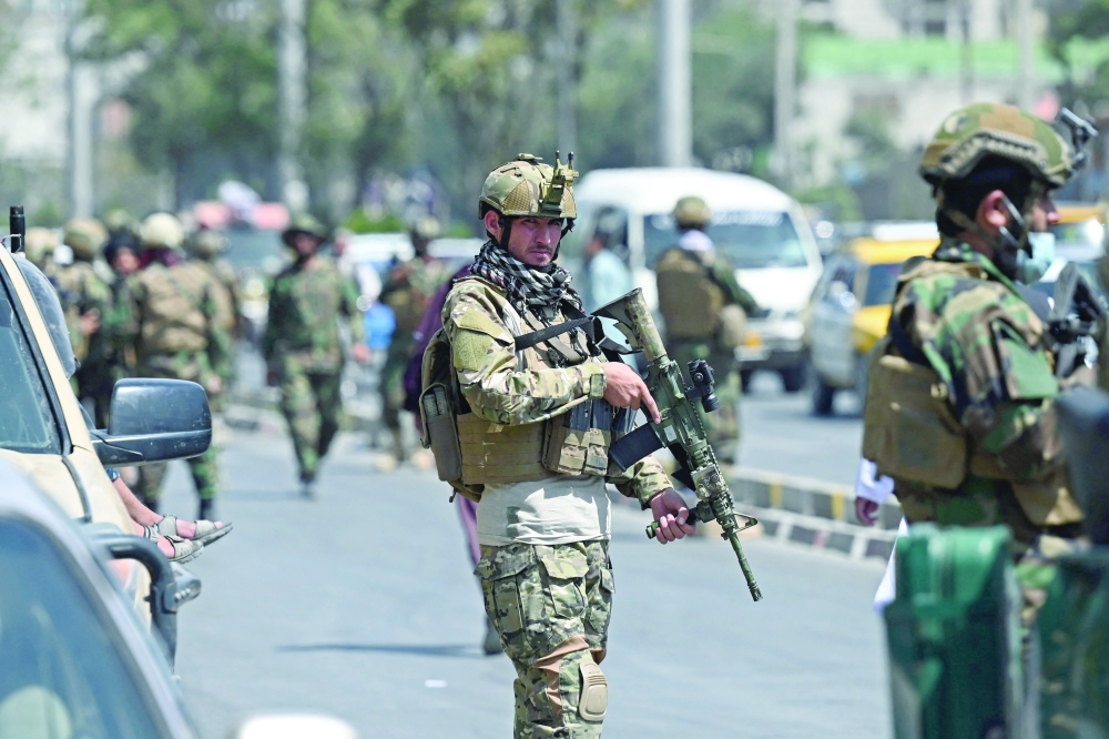 مقاتلو حركة فتح التابعة لطالبان ، وحدة "القوات الخاصة" ، يقفون حراسا في أحد شوارع كابول أمس حيث تلقت تهديدات بتفجير انتحاري خلال المرحلة الأخيرة من عملية الجسر الجوي للجيش الأمريكي من كابول .أ.ف.ب