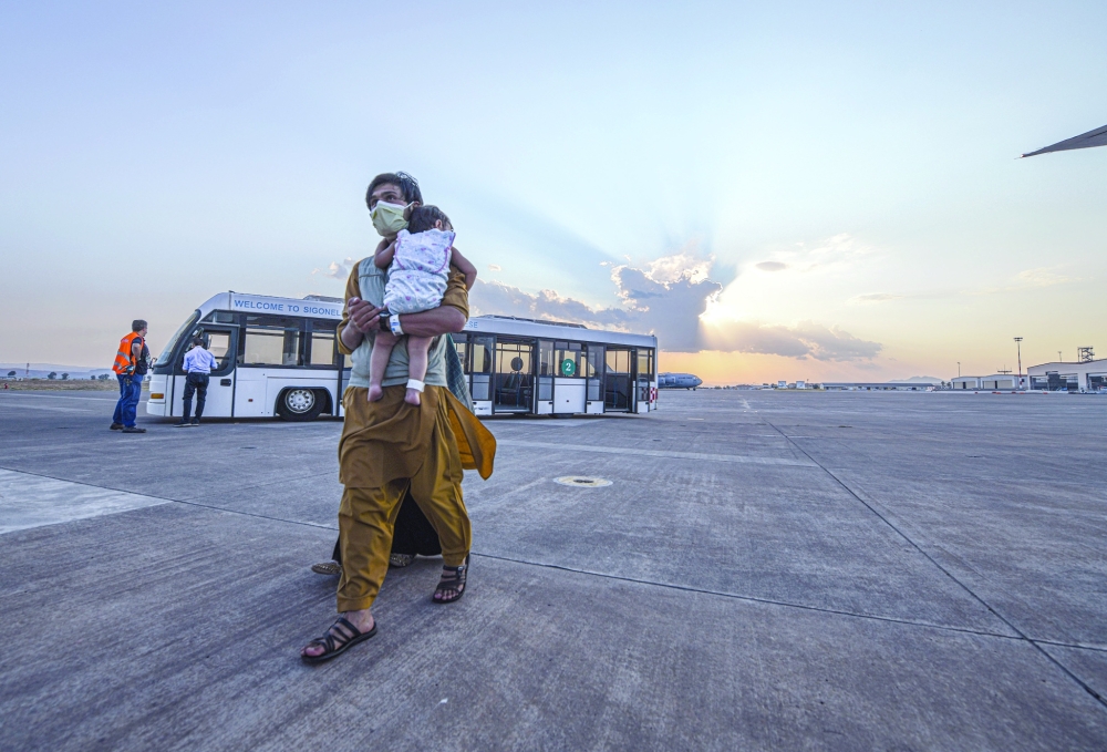 الأشخاص الذين تم إجلاؤهم من أفغانستان يستقلون طائرة بوينج 777 متجهة إلى الولايات المتحدة من محطة سيجونيلا الجوية البحرية بإيطاليا .رويترز