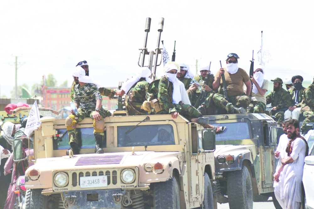 مقاتلو طالبان على متن مركبات تحمل أعلام طالبان في موكب على طول طريق للاحتفال بعد أن سحبت الولايات المتحدة جميع قواتها من أفغانستان.أ.ف.ب 