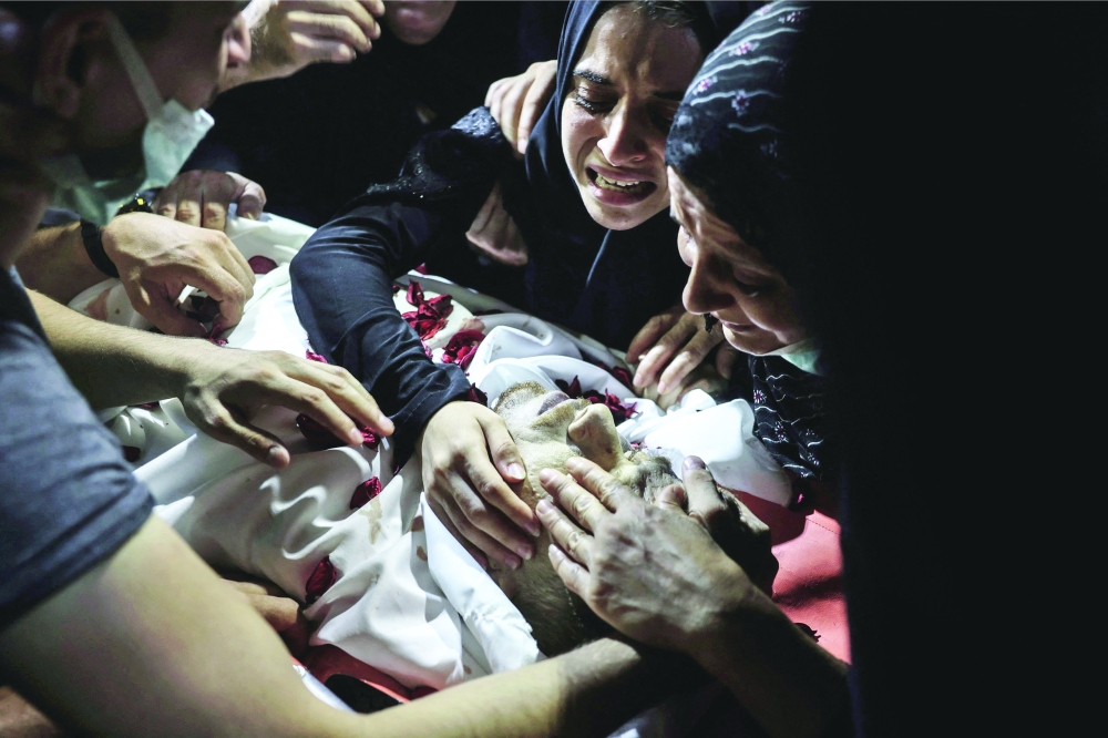 أقارب الشاب الفلسطيني أحمد صالح، يشيعون جنازته عقب استشهاده برصاص جنود إسرائيليين خلال الاشتباكات. أ.ف.ب 