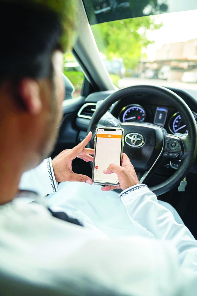 قائد مركبة يتابع تطبيق خدمة أوتاكسي