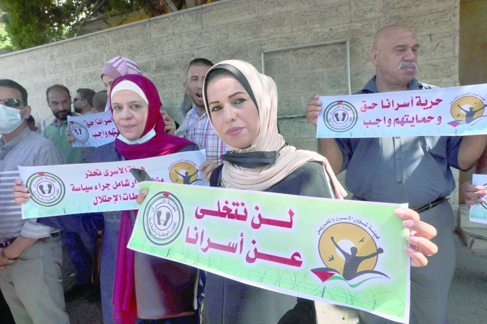 فلسطينيون يرددون هتافات خلال مسيرة بالقرب من مبنى الصليب الأحمر في مدينة غزة لدعم أكثر من ألف سجين في السجون الإسرائيلية.أ.ف.ب 