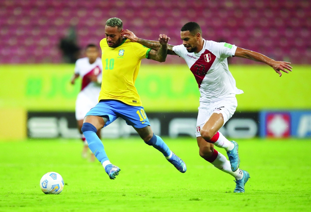 لقطة تنافسية على الكرة بين نيمار واللاعب البيروفي كالينس  ( رويترز ) 