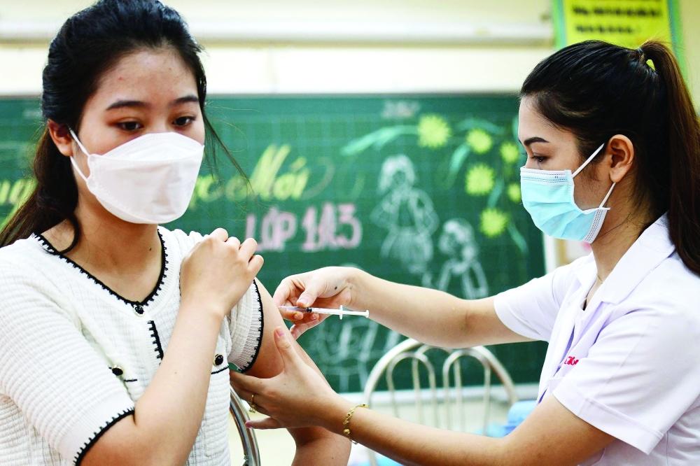 امرأة تتلقى لقاح سينوفارم ضد فيروس كورونا في هانوي بفيتنام امس. أ.ف.ب 