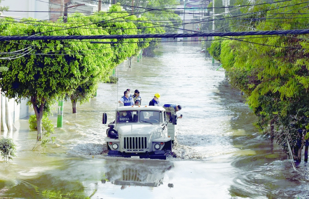 دورية في شارع مغمور بالفيضانات في ولاية هيدالغو بالمكسيك.  "أ ف ب"ط