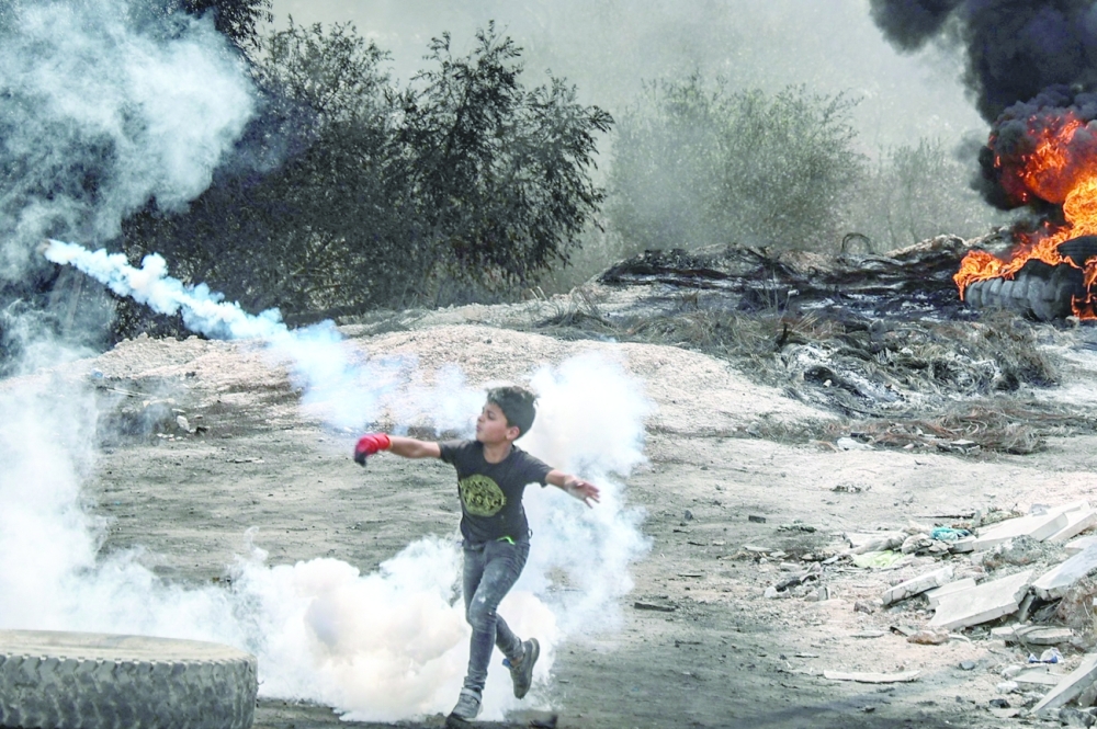 طفل فلسطيني ينضم إلى زملائه المتظاهرين في مواجهات مع قوات الأمن الإسرائيلية في قرية بيتا بالضفة الغربية أمس.  
(أ ف ب)