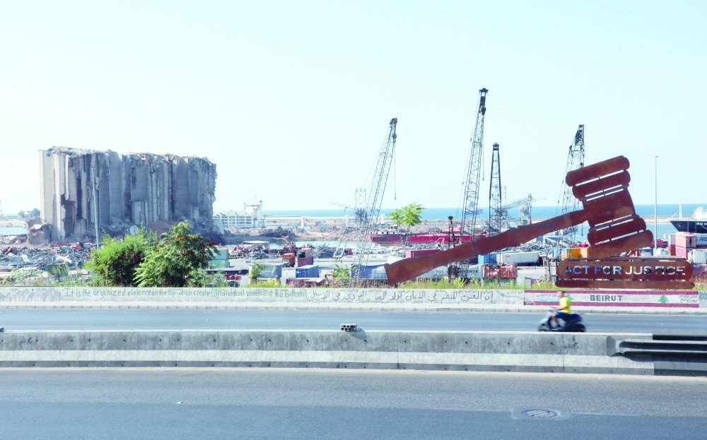 شخص يركب دراجة نارية أمس بالقرب من موقع انفجار ميناء بيروت عام 2020. (رويترز) 