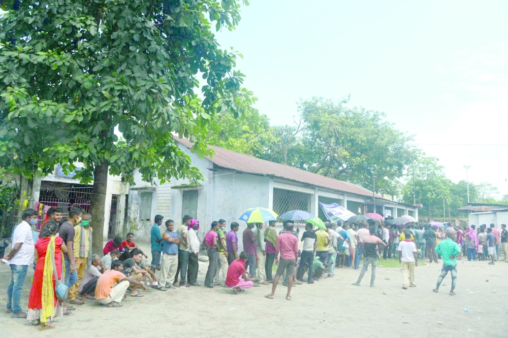 جمع من الناس يقفون في طابور إنتظارا لتلقي جرعة من لقاح كورونا  في سيليجوري أمس. (أ ف ب)
