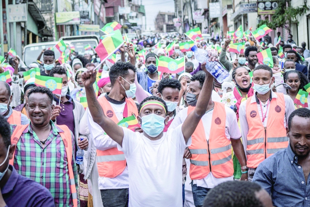  الجماهير الاثيوبية  يسيرون امس في أحد الشوارع  يلوحون بالعلم الوطني بينما يؤدي رئيس الوزراء الإثيوبي أبي أحمد اليمين الدستورية لولاية جديدة مدتها خمس سنوات . أ.ف.ب  