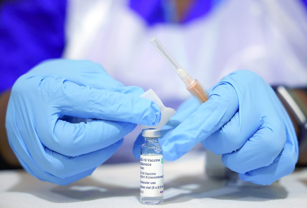 عامل طبي يحضر حقنة بجرعة من لقاح فيروس كورونا استرازنيكا، في مركز التطعيم في لندن. رويترز 