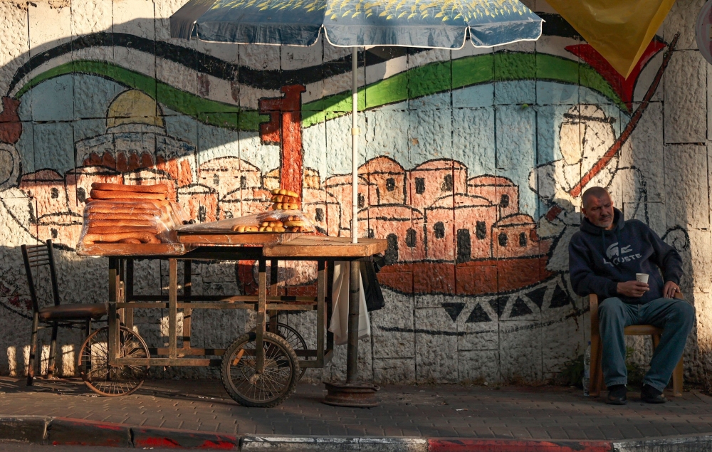 بائع متجول فلسطيني يستريح بالقرب من عربته في مدينة رام الله بالضفة الغربية، اخذت الصورة بتاريخ 5 أكتوبر 2021.     ا ف ب