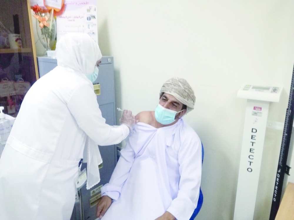 مواطن يتلقى التطعيم بعبري
