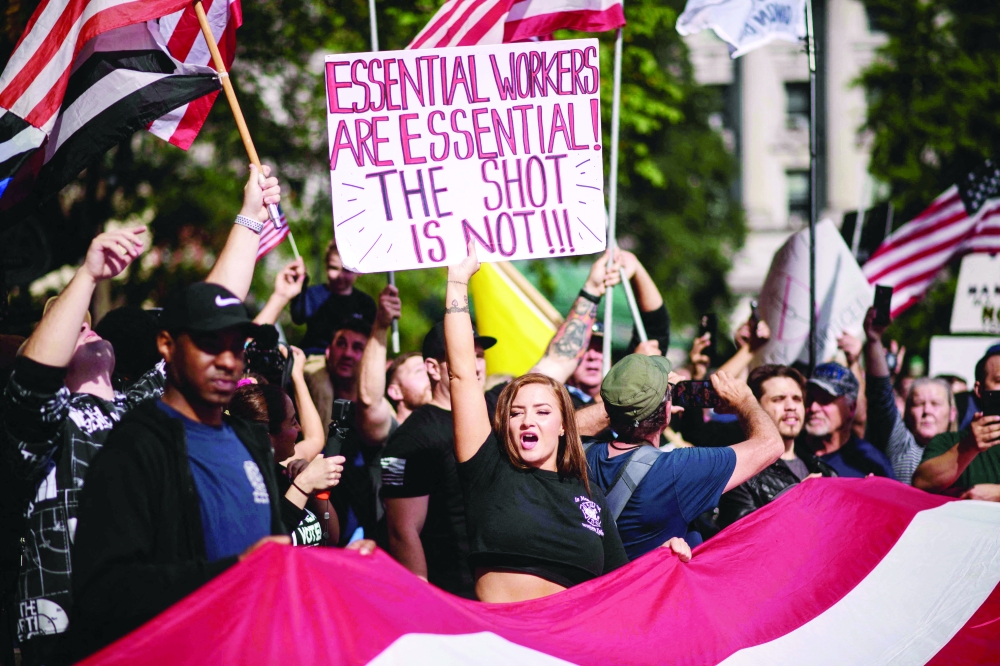 عمال يحملون لافتات ويهتفون بالشعارات خارج مبنى البلدية خلال احتجاج ضد تفويض لقاح كوفيد -19 ، في نيويورك أمس حيث 
 خرج رجال الإطفاء في نيويورك الذين يترددون في اللقاحات إلى الشوارع للتظاهر ضد مطلب المدينة بتلقيحهم ضد Covid-19 أو المخاطرة بفقدان وظائفهم.أ.ف.ب
