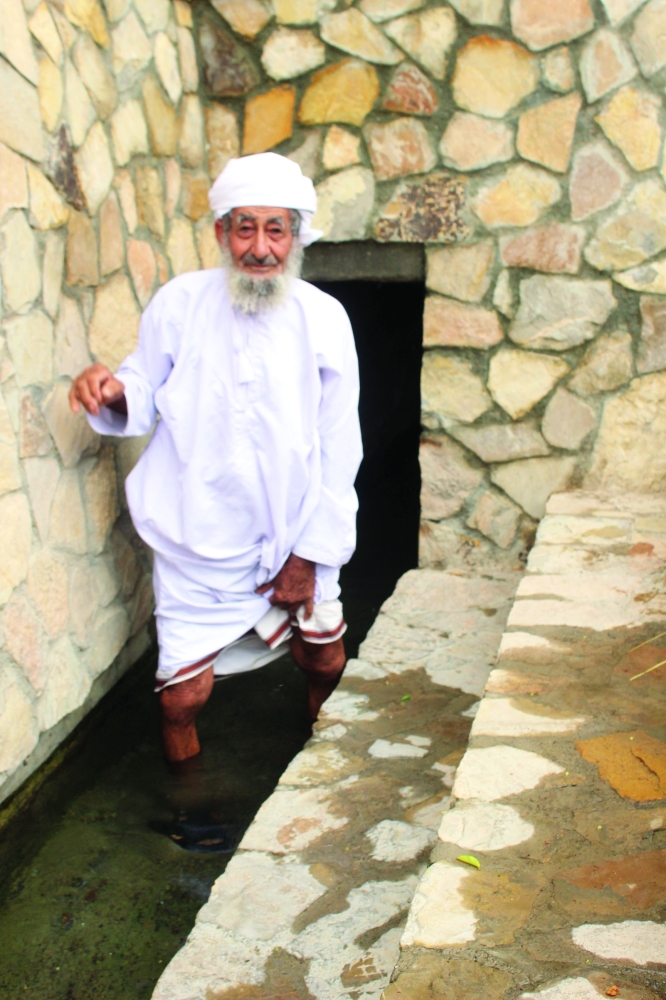 يغمس رجليه في الفلج عند الشريعة