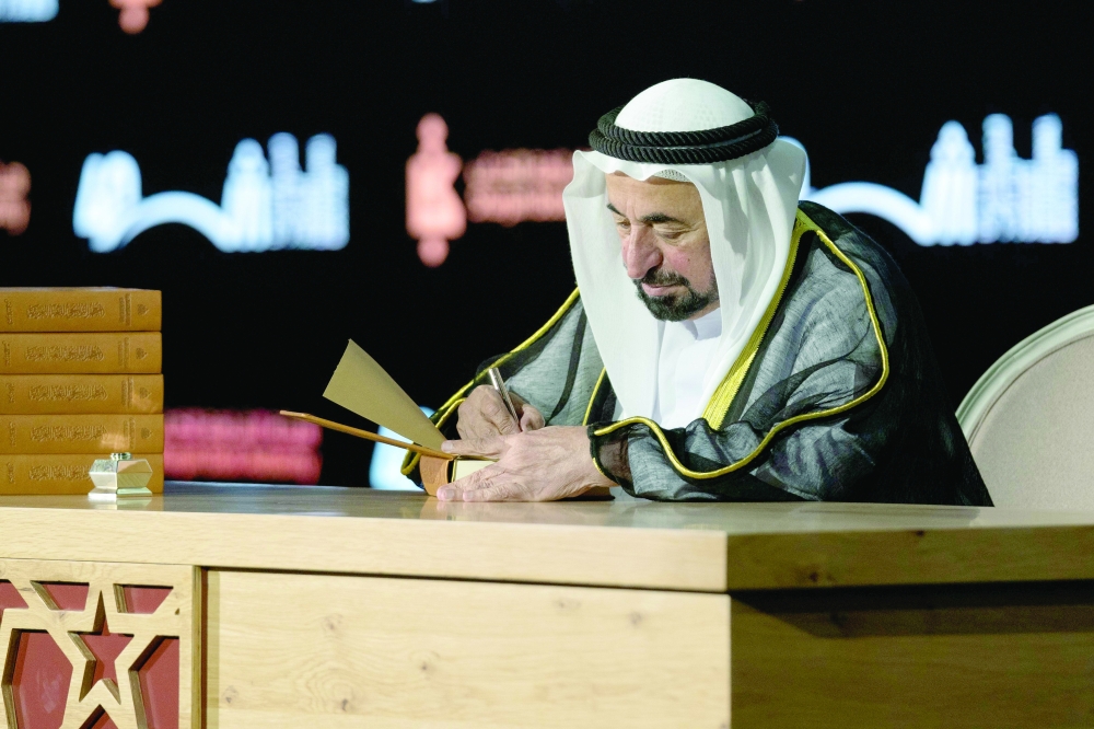 حاكم الشارقة أثناء التوقيع على معجم تاريخ اللغة العربية