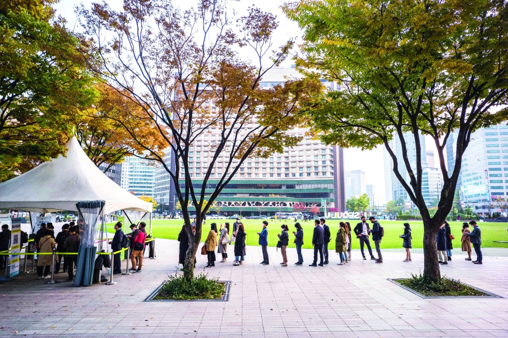 أشخاص يصطفون خارج مركز اختبار فيروس كورونا في سيول، امس.  ا ف ب