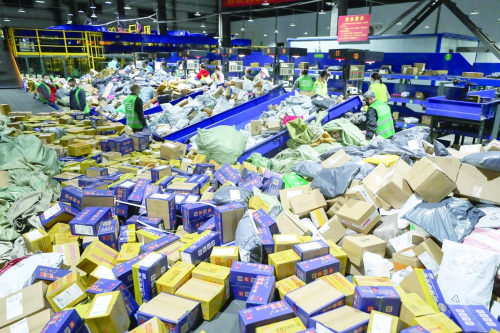 عمال يقومون بفرز الطرود في شركة لوجستية بمقاطعة هونان بوسط الصين،في «يوم العزاب»، الذي يعد أكبر يوم تسوق في العام. ا ف ب