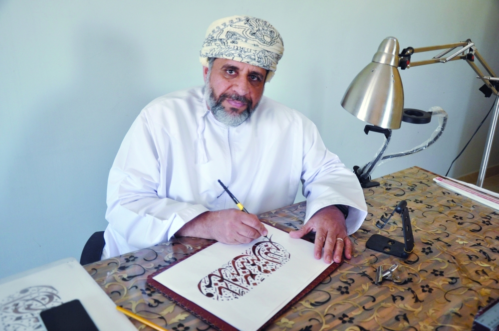 الخطاط هلال يمارس هواية الخط العربي