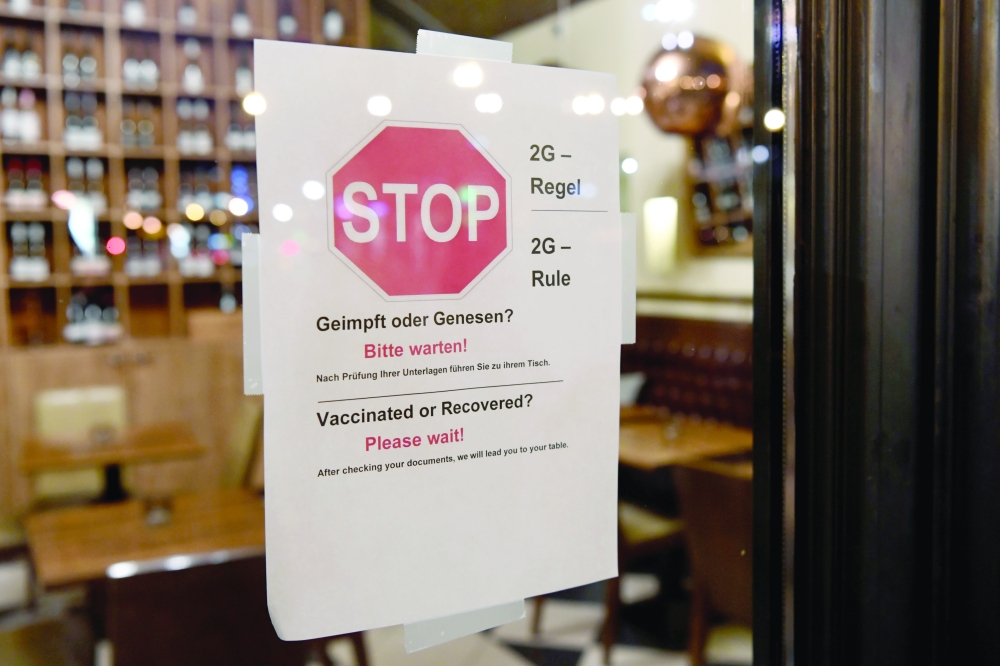 عرض علامة قاعدة '2G' ، التي تسمح فقط لأولئك الذين تم تطعيمهم أو تعافوا من مرض كورونا بدخول المطاعم والمناطق الداخلية الأخرى ، عند مدخل مطعم في برلين. رويترز