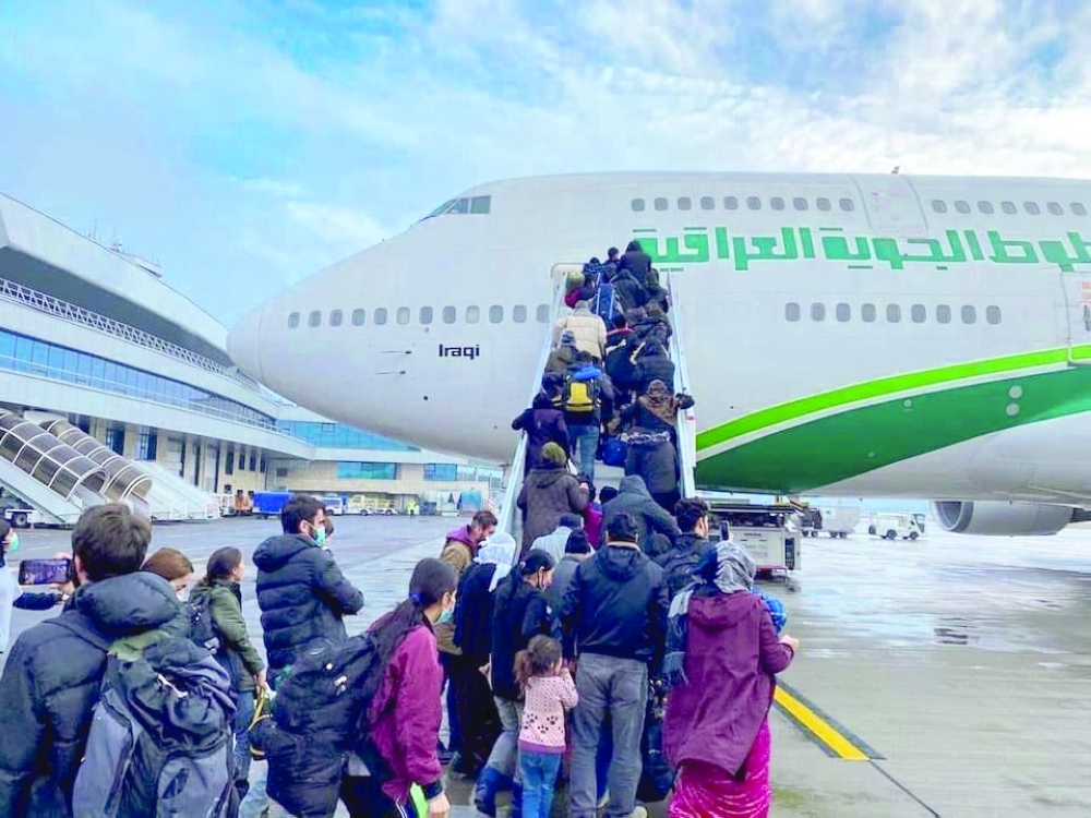 مهاجرون عراقيون يستقلون الطائرة في رحلة إجلاء في مطار مينسك ، بيلاروسيا.رويترز