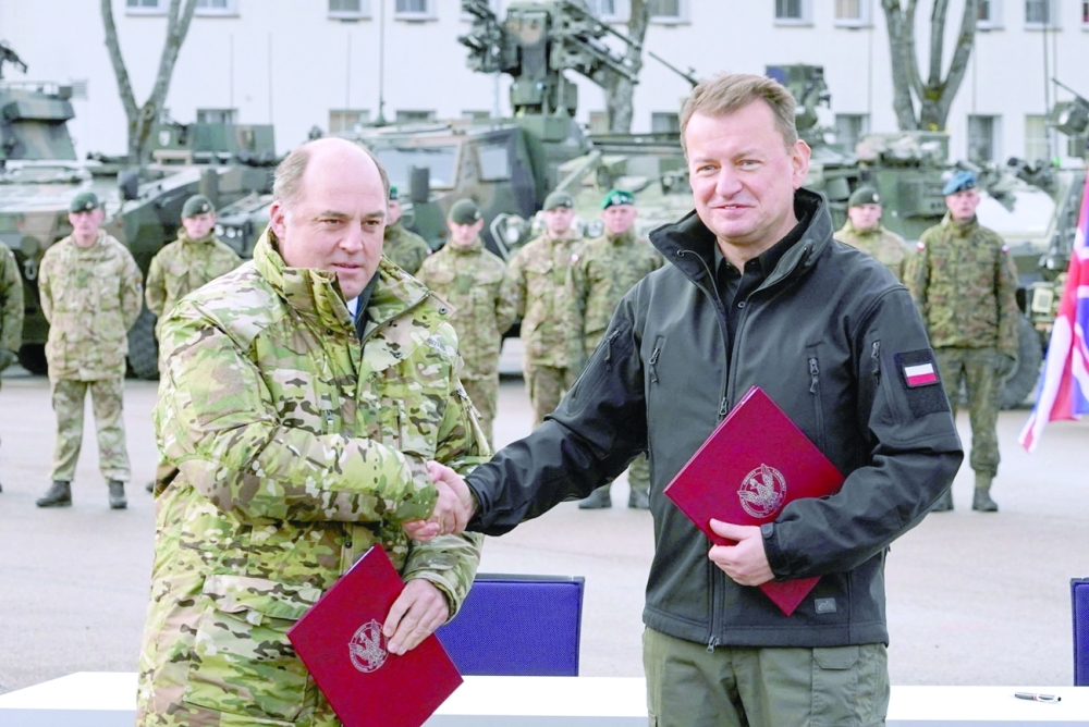 وزير الدفاع البريطاني بن والاس ووزير الدفاع الوطني البولندي ماريوس بلاشتشاك يحضران حفل توقيع إعلان نية التعاون على تطوير قدرات القوات المسلحة البولندية، في قاعدة عسكرية في بيموو بيسكي ، بولندا.أمس .رويترز