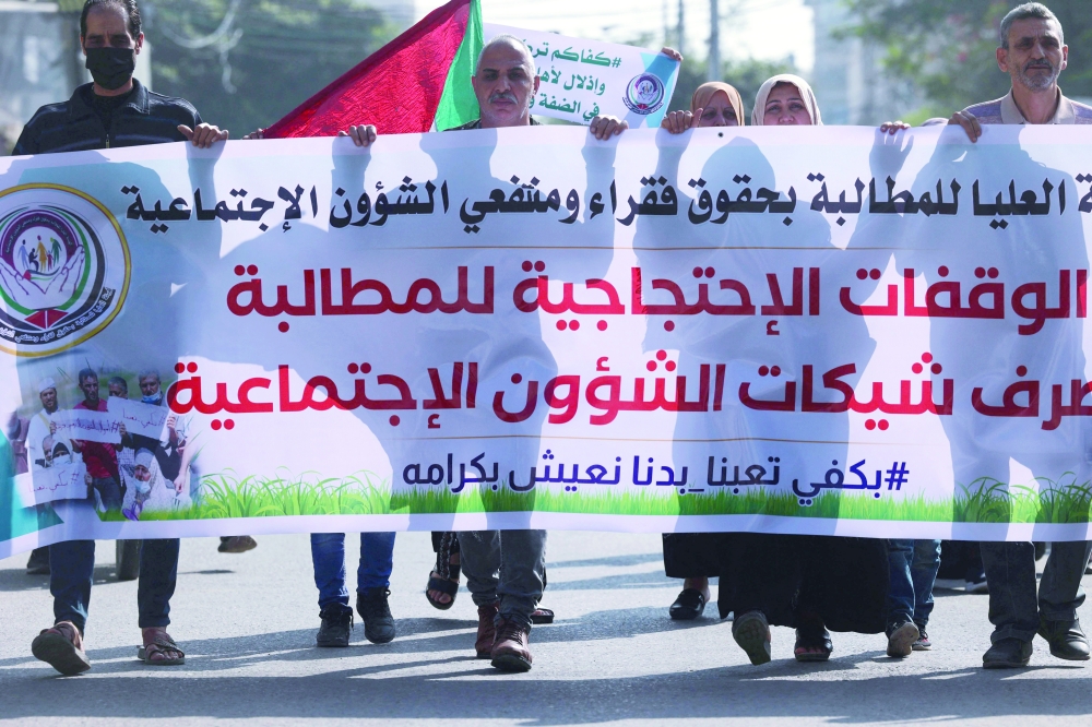 الفلسطينيون الذين يتلقون مساعدات مالية واجتماعية يحضرون احتجاجًا بجوار مقر برنامج الأمم المتحدة الإنمائي خلال زيارة قام بها وفد من الاتحاد الأوروبي أمس.أ.ف.ب 