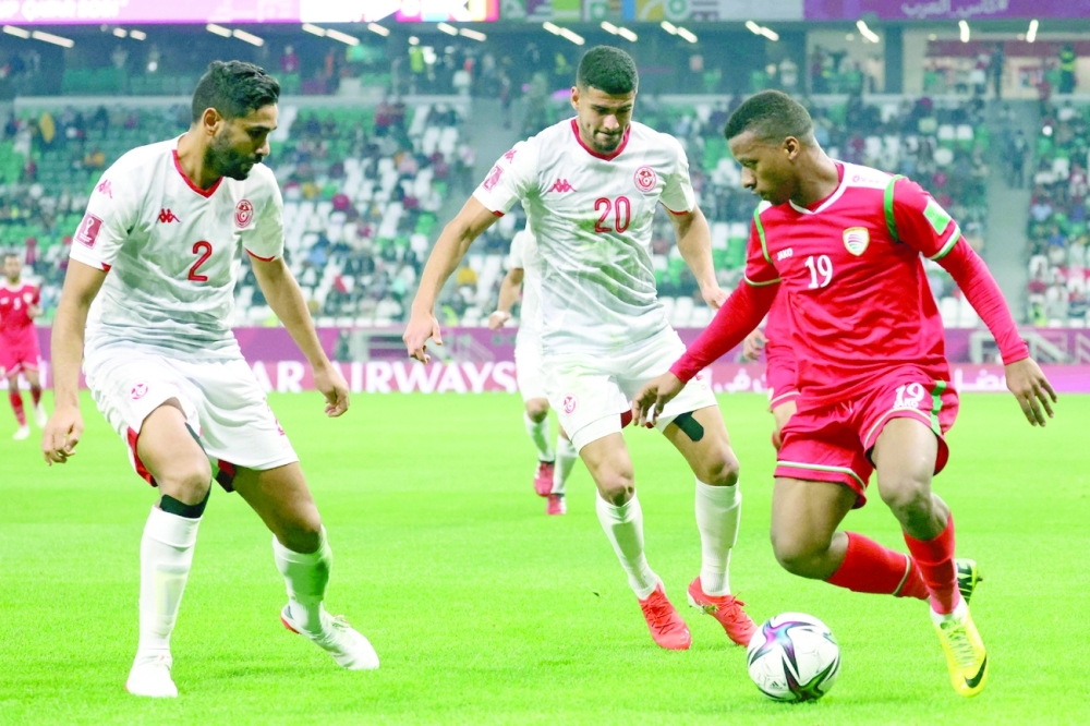 المنذر العلوي يستحوذ على الكرة في ظل مراقبة من لاعبا المنتخب التونسي