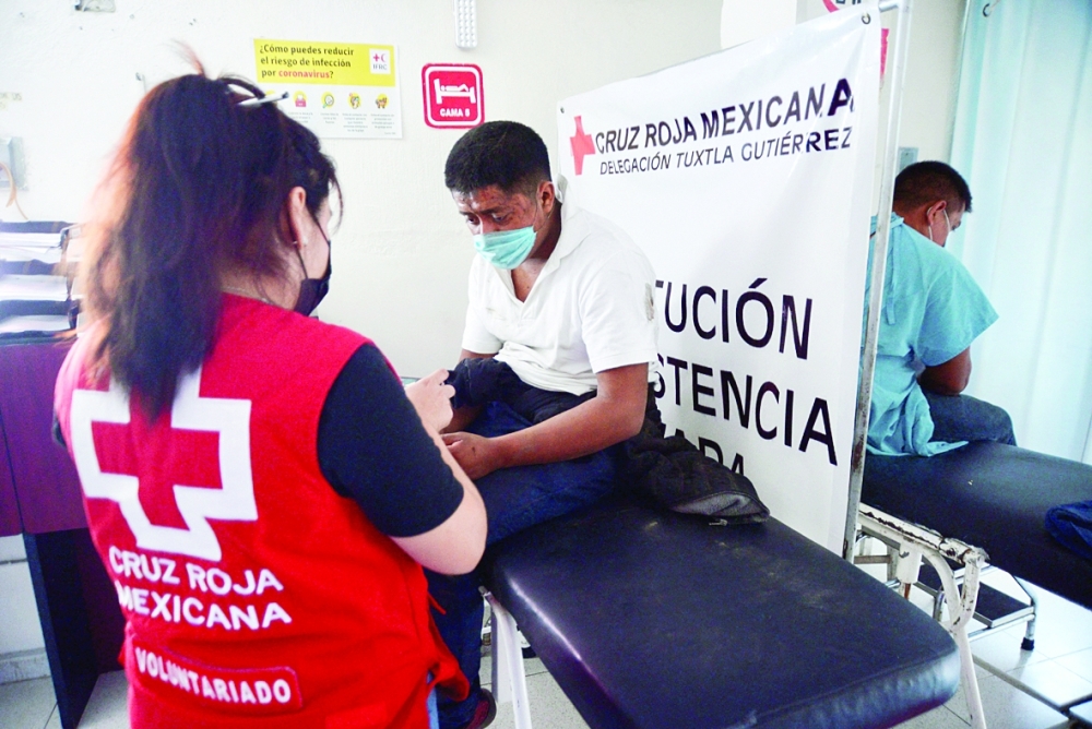 مسعفه تابعه للصليب الأحمر تساعد رجلاً أصيب في حادث الشاحنة الذي أسفر عن مقتل عدة أشخاص، معظمهم مهاجرون من جواتيمالا. رويترز 