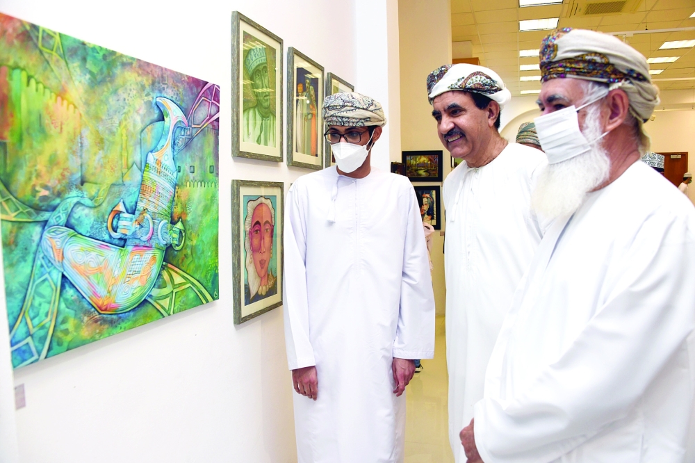 محمود السليمي والحضور يستمعون لشرح حول الأعمال الفنية المعروضة