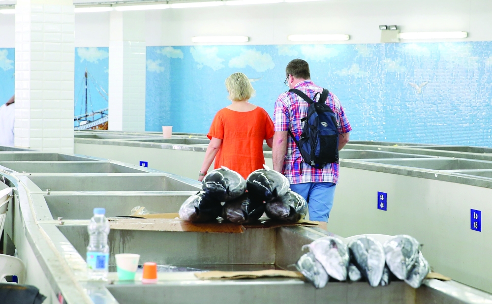 سياح داخل سوق السمك بمطرح