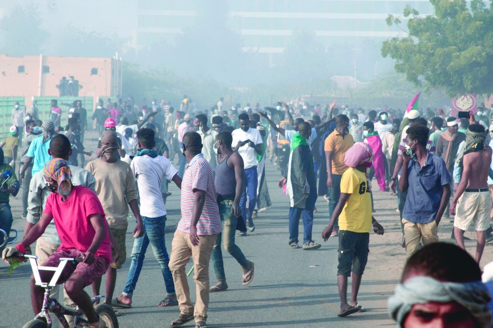 متظاهرون سودانيون يتجمعون وسط الغاز المسيل للدموع الذي أطلقته قوات الأمن في شارع القصر قبيل اعلان حمدوك استقالته.أ.ف.ب