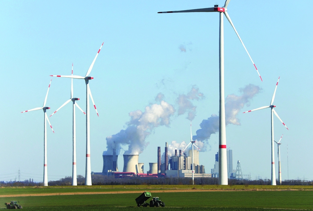 محطات طاقة الرياح التابعة للمرفق الألماني، إحدى أكبر شركات الكهرباء في أوروبا، أمام محطات توليد الطاقة التي تعمل بالفحم البني في شمال غرب مدينة كولونيا بألمانيا.