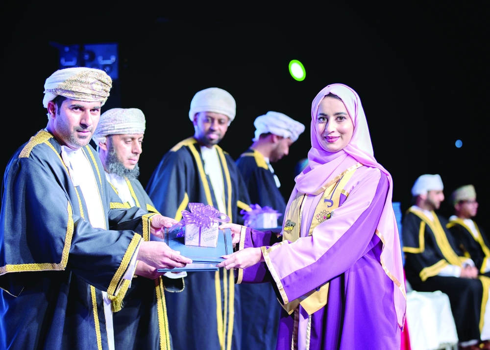 إحدى الخريجات تتسلّم شهادتها