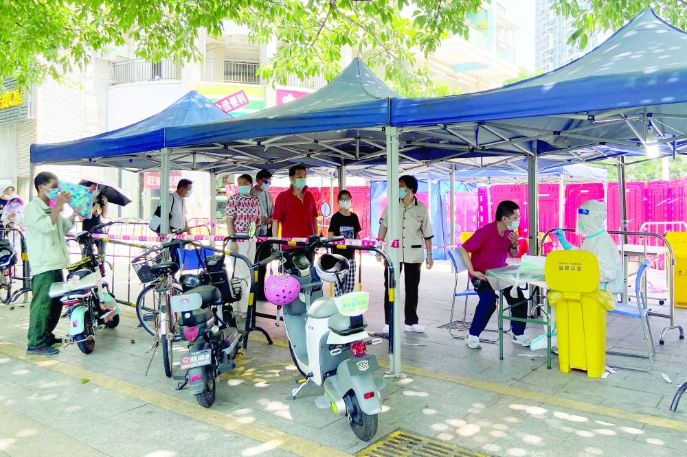 السكان يصطفون لإجراء اختبار فيروس كورون في موقع لاختبار الحمض النووي في شنتشن بمقاطعة جوانجدونج بالصين