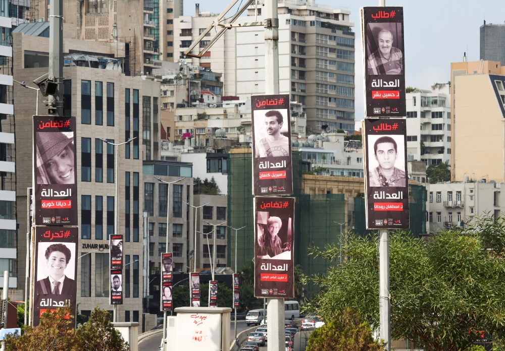 ملصقات لضحايا انفجار ميناء بيروت في أغسطس 2020 معلقة على أعمدة شوارع على طول طريق سريع في بيروت. رويترز