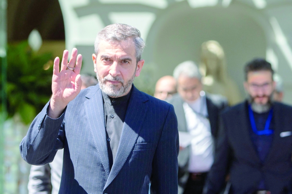كبير المفاوضين النوويين لإيران علي باقري يلوح بيده أثناء مغادرته قصر كوبرغ بفيينا أمس.  "أ ف ب"