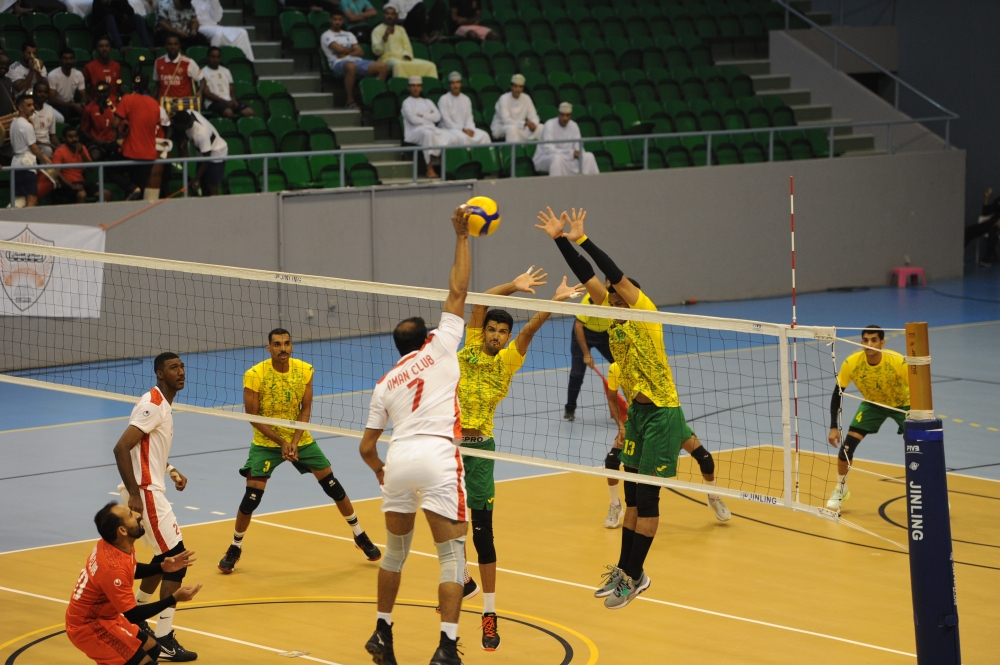 لاعب نادي عمان وليد البادي يسدد الكرة وسط حائط الصد من لاعبي السيب محمود السعدي وأحمد التوبي