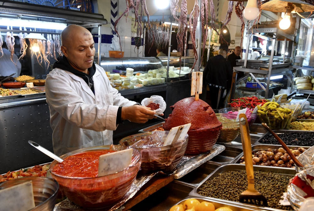 صاحب المحل يقدم الهريسة التونسية. "أ.ف.ب"